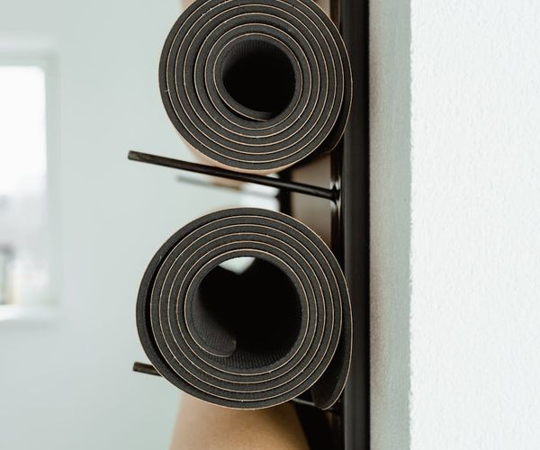 Bright and clean yoga studio interior with rolled mats.